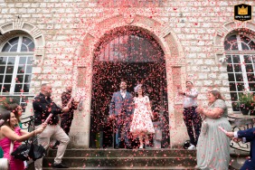 The bride and groom left the Mairie de Saint Gratien in France. Red hearts showered them. The couple walked under the hearts after their wedding ceremony.